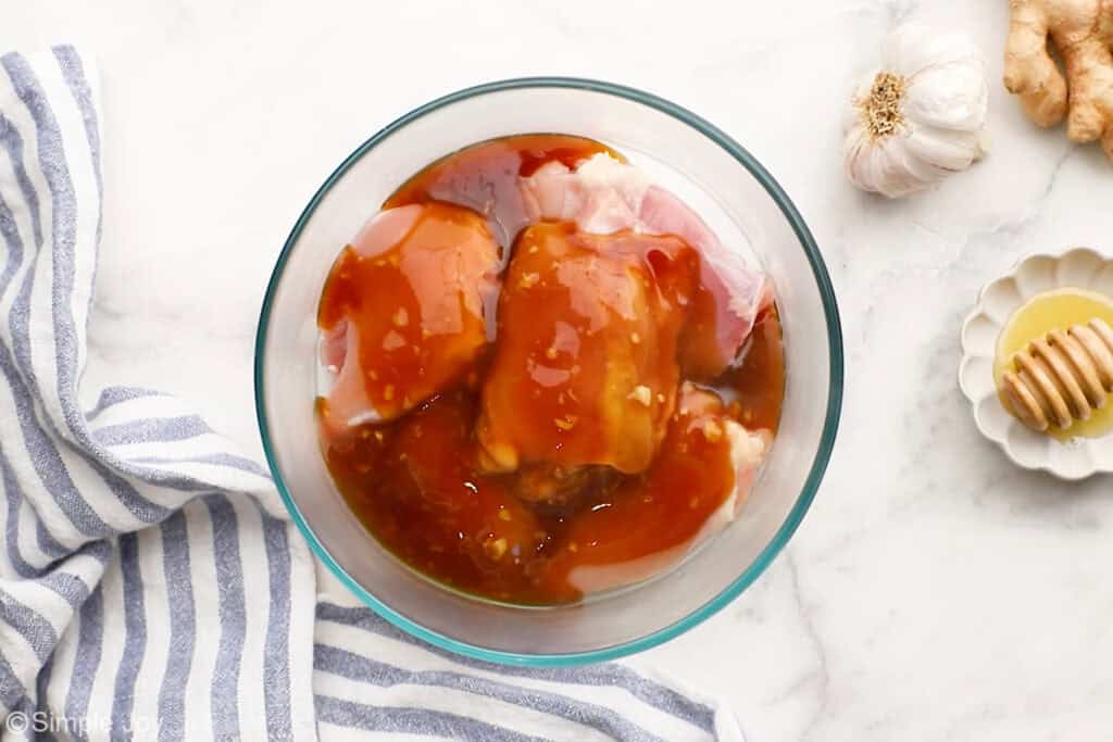 Overhead of bowl of chicken and teriyaki sauce to make teriyaki chicken recipe