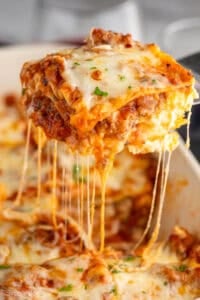 Piece of homemade lasagna being lifted out of pan