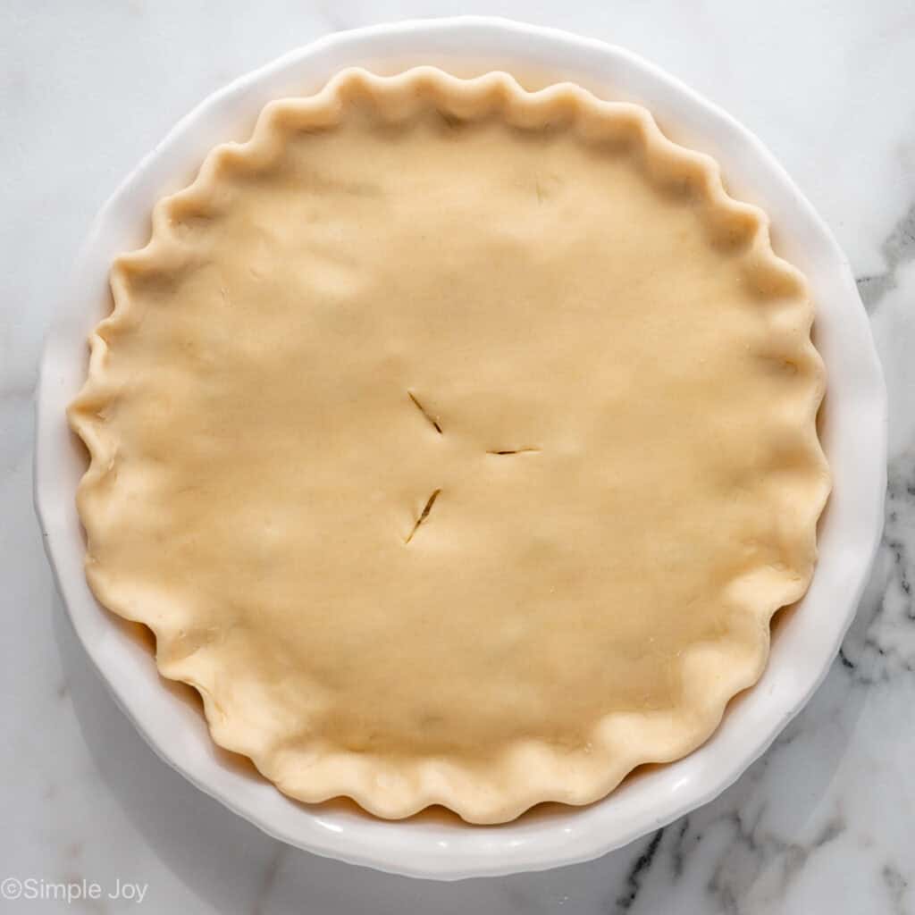 Overhead of pie plate of easy chicken pot pie topped with pie crust