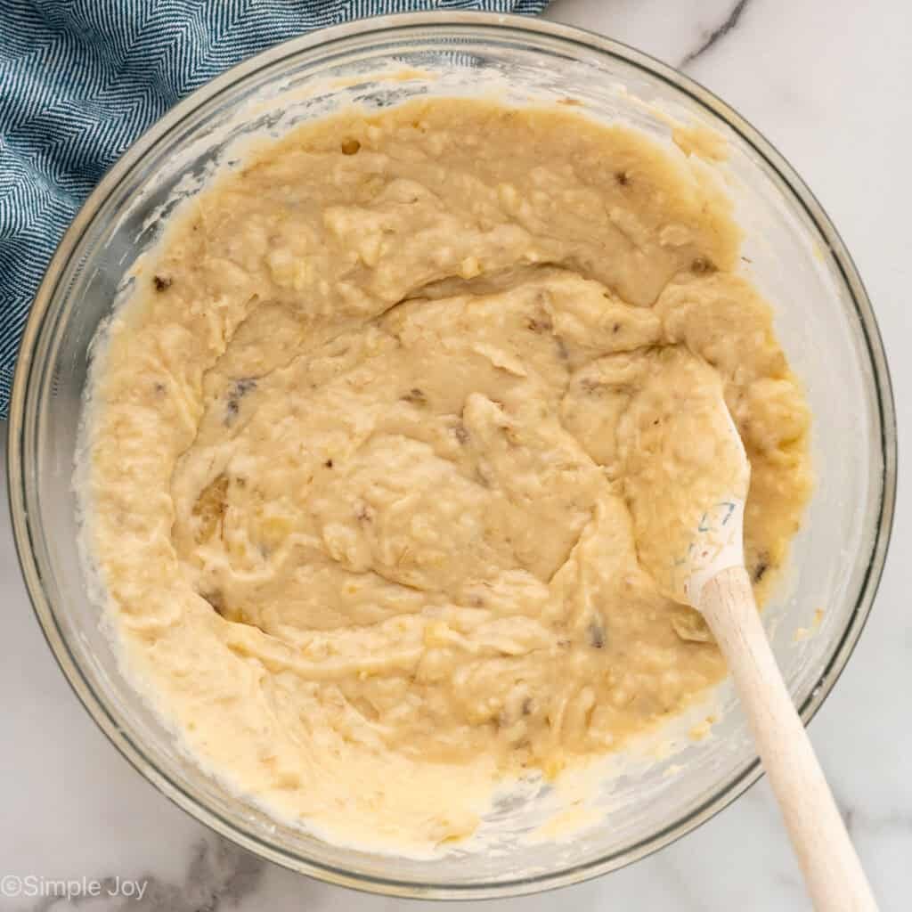 Overhead of bowl of banana bread ingredients with spatula