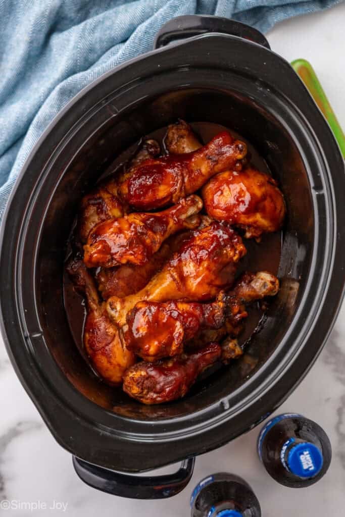 Overhead of chicken drumsticks ingredients in a slow cooker.