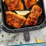 Pinterest graphic for air fryer salmon. Image shows overhead of air fryer basket of salmon and lemon wedges garnished with fresh parsley. Says "air fryer salmon simplejoy.com"