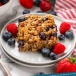 Pinterest graphic for baked oatmeal. Image shows piece of baked oatmeal on a plate surrounded by fresh blueberries and raspberries. Pan of baked oatmeal sitting in background. Says "tried & tested baked oatmeal simplejoy.com"