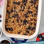 Pinterest graphic for baked oatmeal recipe. Image shows overhead of pan of baked oatmeal surrounded by fresh berries. Says "baked oatmeal simplejoy.com"