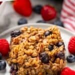 Pinterest graphic for baked oatmeal. Says "the best baked oatmeal simplejoy.com" Image shows piece of baked oatmeal on a plate surrounded by fresh berries