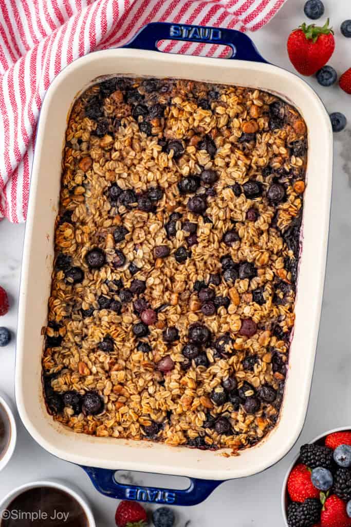 Overhead of pan of baked oatmeal with fresh berries sitting beside