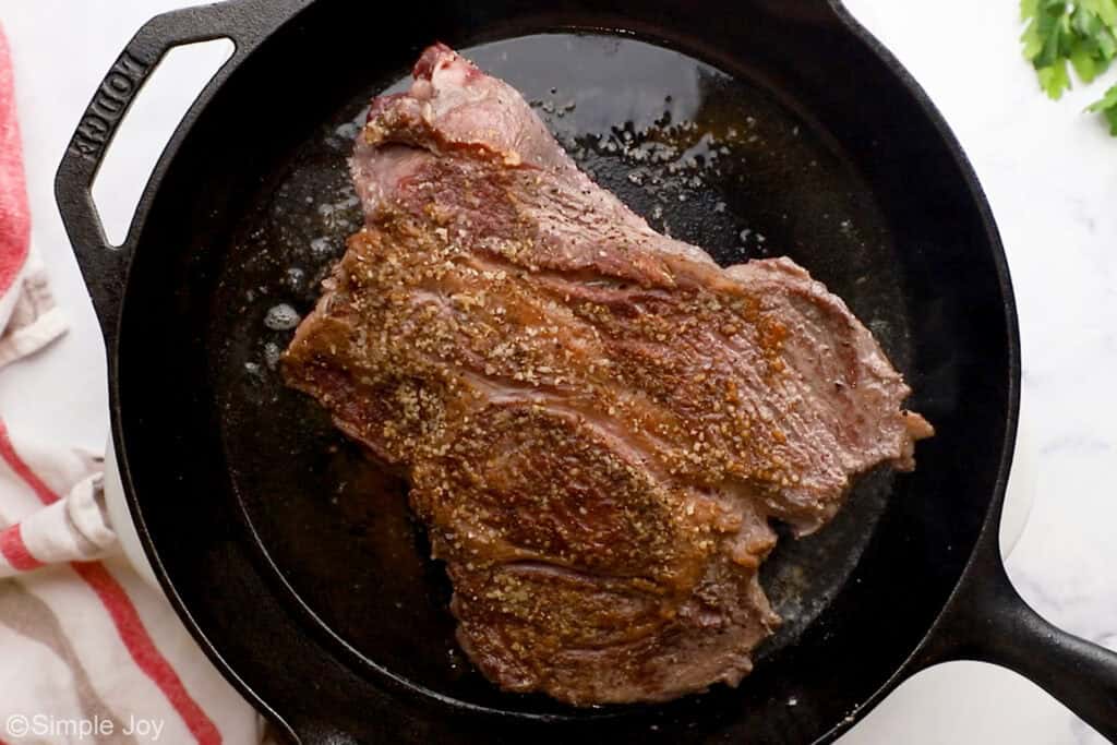 Overhead of pot roast in a skillet to make slow cooker pot roast