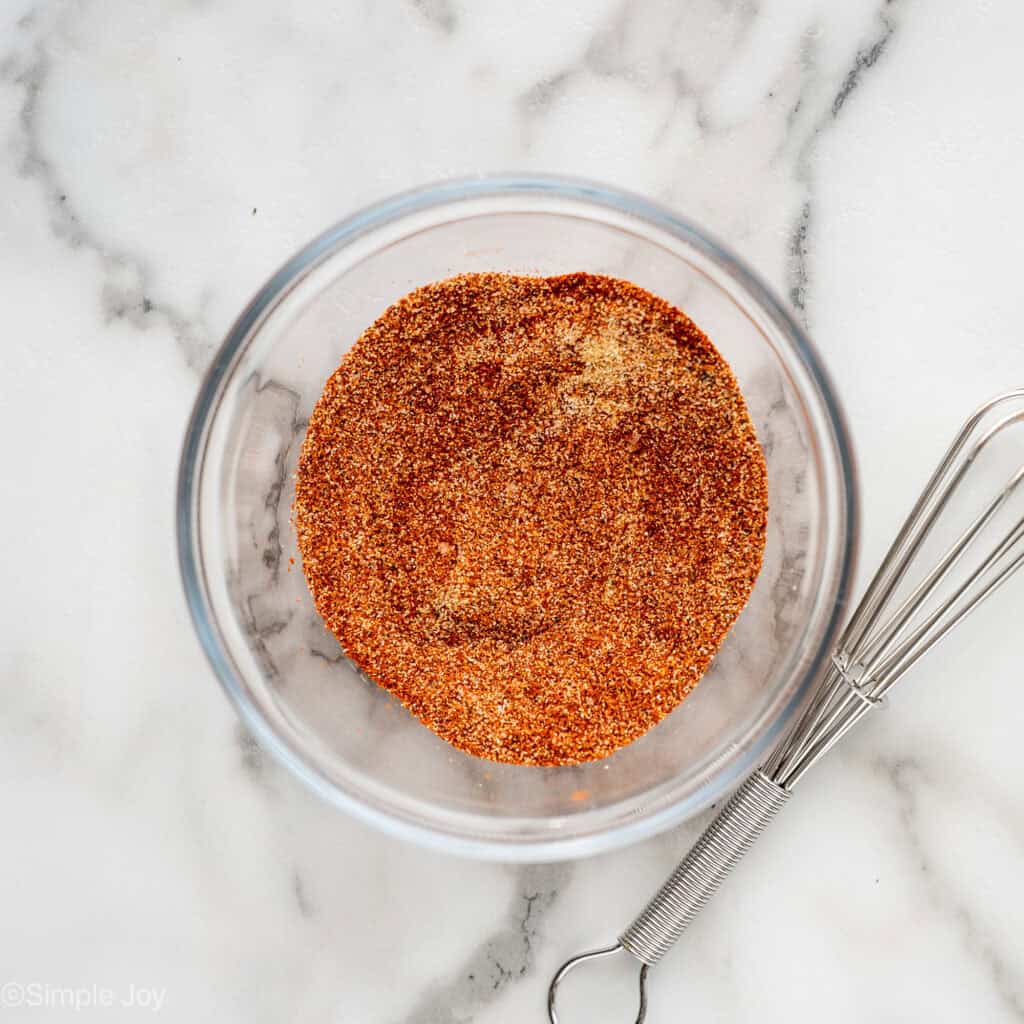 Overhead of glass bowl of seasonings whisked together