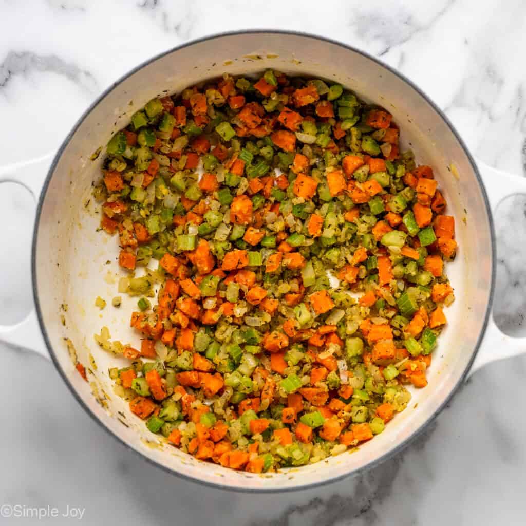 overhead of a dutch oven with sauteed vegetables coated in flour