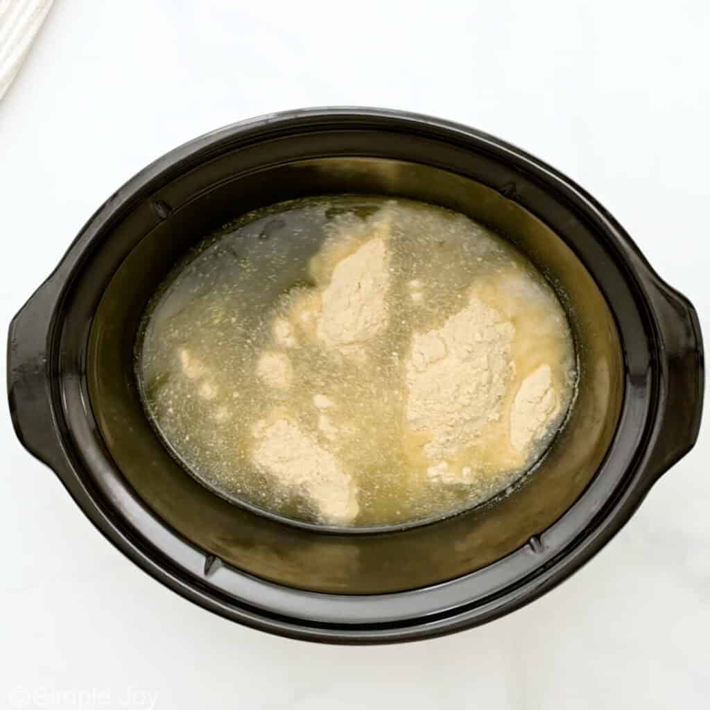 Overhead of slow cooker of broth and masa harina
